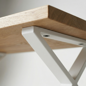 Detalle de mesa de centro industrial en color blanco con tapa de madera de pino